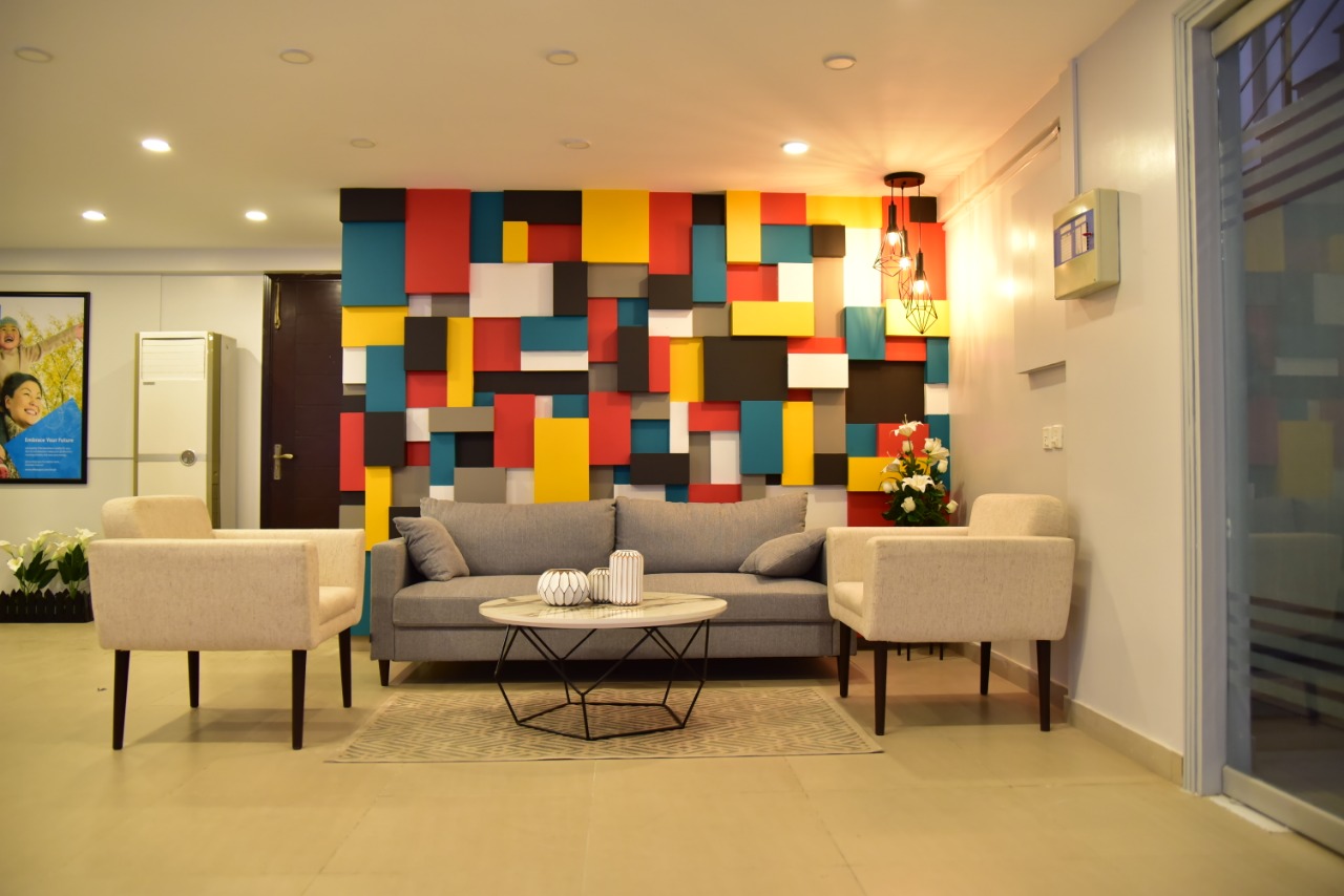 Reception lounge with a blocked-colour accent wall and soft seating
