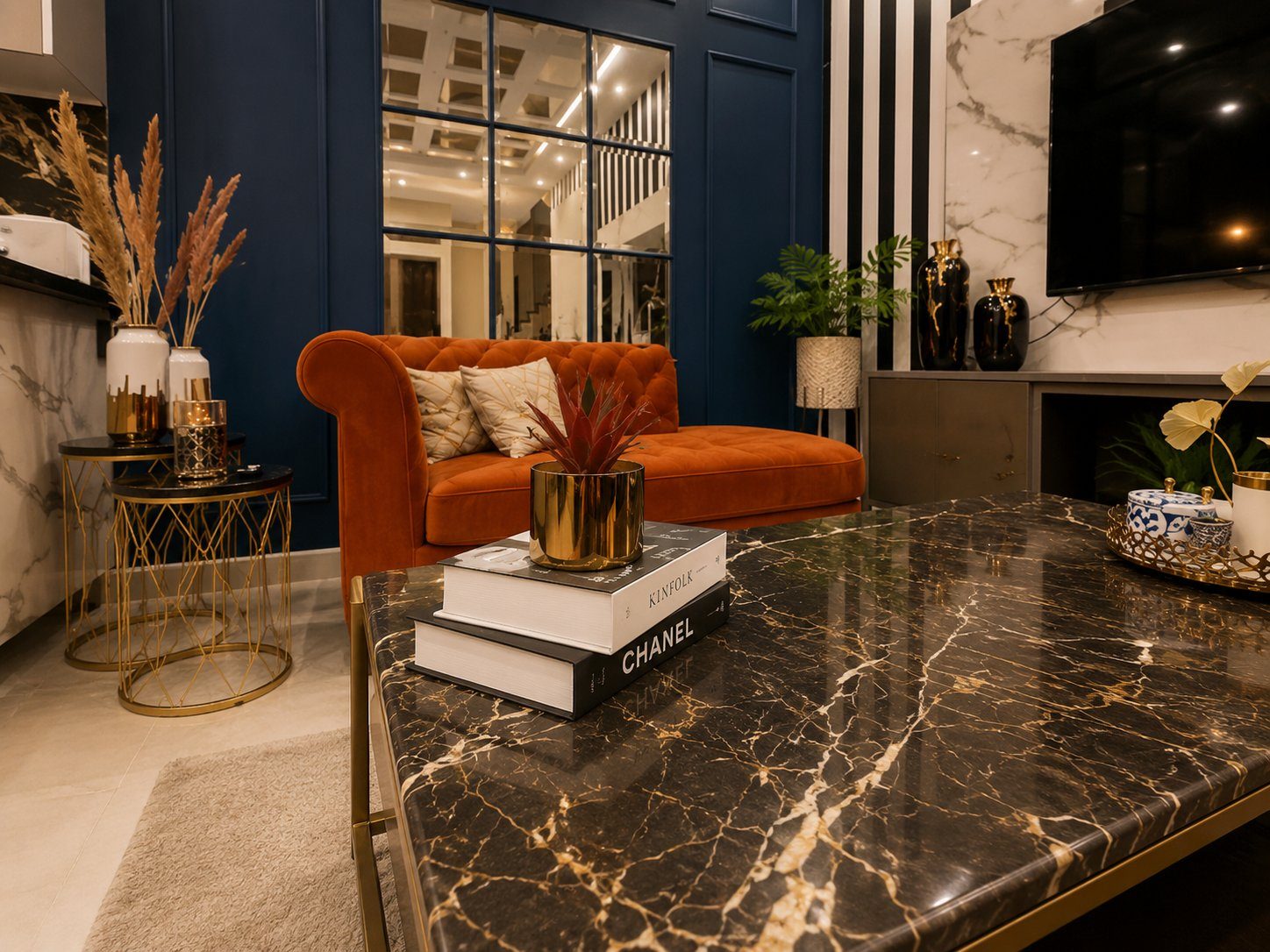 Coffee table styling with Chanel and Kinfolk books, orange sofa and blue wall