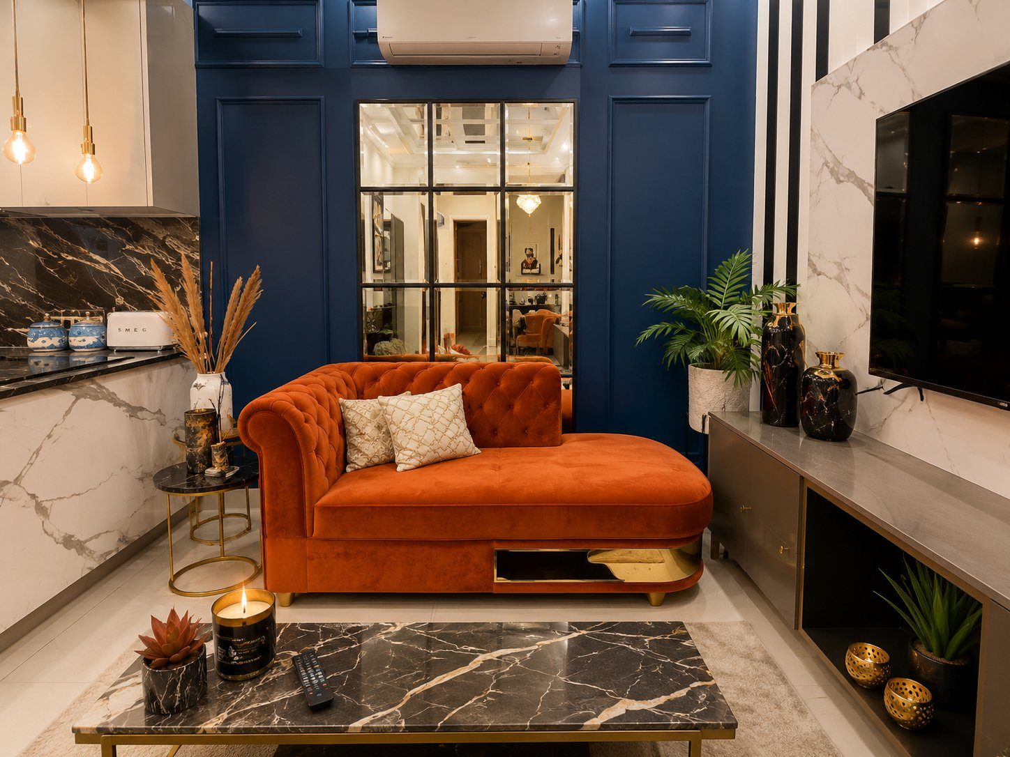 Orange chaise sofa with marble coffee table and gold accents in kitchen-adjacent lounge